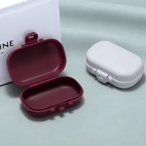 Portable plastic storage boxes for jewelry or pills in burgundy and light grey