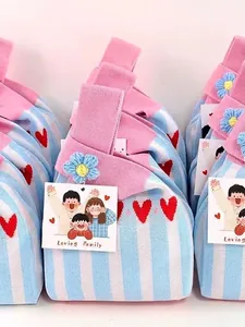 Small knitted wrist bag with blue stripes and red heart patterns for wedding or gift packaging
