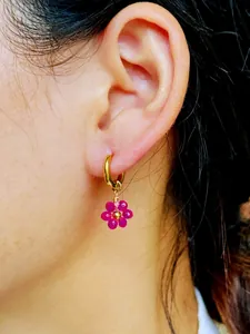 Gros plan détaillé de boucles d'oreilles fleur en perles roses faites à la main