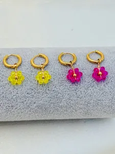 Détail de créoles en acier inoxydable faites main avec fleurs en cristal