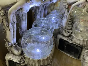 Detail shot of the glowing crackle glass ball on solar fairy garden resin light