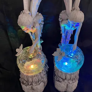 Close-up detail of solar flower fairy resin statues with glowing cracked crystal balls