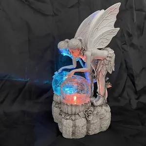 Detailed view of solar fairy garden statue with glowing blue and orange crystal balls