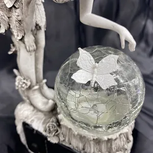 Detailed macro of the cracked crystal ball with a white butterfly on solar garden fairy