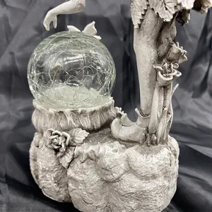 Close-up of garden fairy resin ornament with cracked glass crystal ball solar light