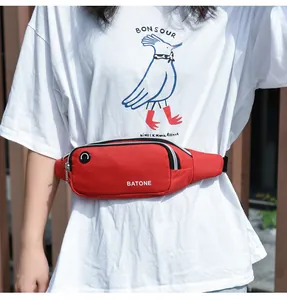 Close-up of a red waterproof sports waist bag with earphone hole and white BATONE logo