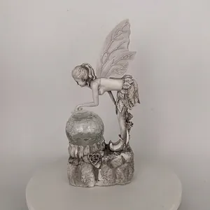 Intricate detail of resin fairy garden ornament with glowing crackle glass solar ball