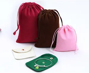 Detail view of various colorful velvet drawstring jewelry pouches and snap button organizers.