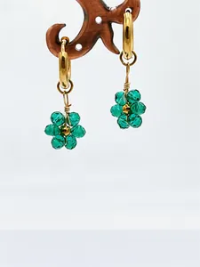 Gros plan de boucles d'oreilles fleurs en cristal vert faites à la main avec créoles