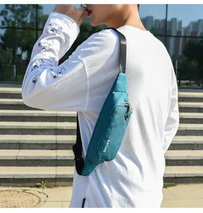 Man wearing a teal waterproof sports waist bag over a white printed long sleeve shirt.