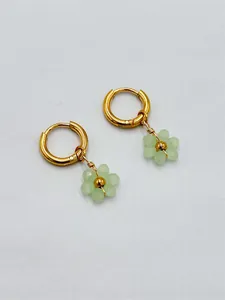 Vue détaillée des boucles d'oreilles créoles dorées faites main avec fleurs vertes