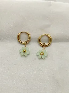 Gros plan détaillé de boucles d'oreilles dorées faites main avec fleurs perlées vertes
