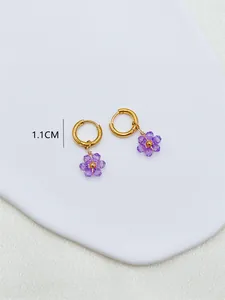 Vue de détail de boucles d'oreilles fleurs violettes avec une taille de 1,1 cm.