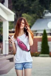 Stylish pink waterproof sport fanny pack worn as a crossbody bag for outdoor running