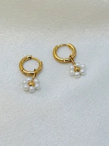 Vue détaillée de boucles d'oreilles fleurs en perles faites à la main en inox poli.