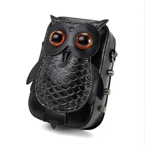 Detailed view of punk-style owl crossbody bag with orange eyes and textured scales.