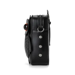 Detailed side view of a black punk owl-shaped crossbody bag with silver studs