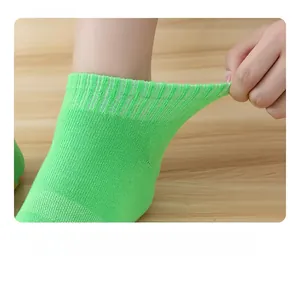 Detail view of the high-stretch elastic cuff on a bright green non-slip yoga sock