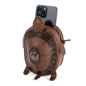 Detailed macro shot of a punk-style brown leather turtle-shaped crossbody bag with a phone inside