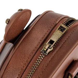 Close-up detail of antique brass zipper on brown vintage owl crossbody bag