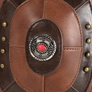 Macro detail of punk owl crossbody bag featuring leather texture and red stone medallion