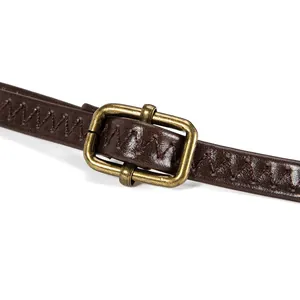 Close-up detail of brown faux leather bag strap with vintage brass buckle and zigzag stitching
