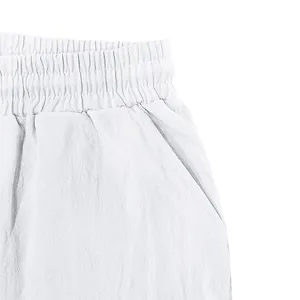 Detail shot of white men's linen shorts showing elastic waistband and side pocket.