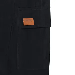 Close-up detail of men's cargo shorts pocket with a classic leather sport patch.