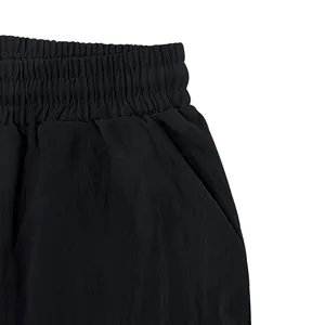 Detail view of men's black breathable shorts featuring elastic waistband and side pocket