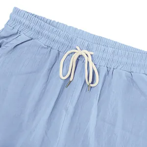 Close-up of men's light blue linen shorts with elastic waist and white drawstring.