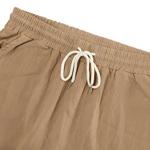 Close-up of khaki linen shorts featuring elastic waist and white drawstring.