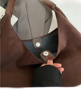 Detaillierte Makroansicht des hochwertigen Magnetverschlusses an einer braunen Wildledertasche