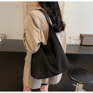 Schwarze Wildleder-Einkaufstasche am Modell, Pendler-Schultertasche mit großem Volumen.