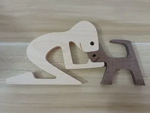 Detail view of handcrafted wooden sculpture depicting a person and dog interaction