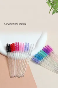 Close-up of disposable eyelash brushes with colorful spiral heads and glittery handles