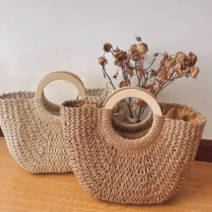 Rustic straw tote bags with circular wooden handles and dried floral decor