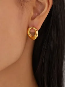 Close-up detail of trendy gold-plated organic hoop earrings worn by an Asian model