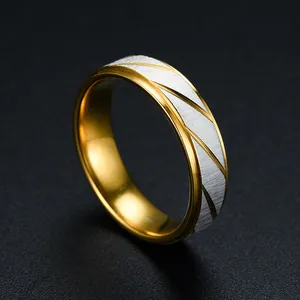 Close-up detail of two-tone gold and silver ring with diagonal engraved lines