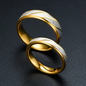 Detail macro view of two-tone gold and silver rings with diagonal brushed texture