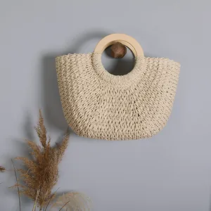Detail showing natural weave texture and wooden handles of this retro straw beach bag