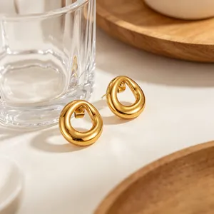 Minimalist irregular round titanium steel gold earrings in a warm lifestyle setting