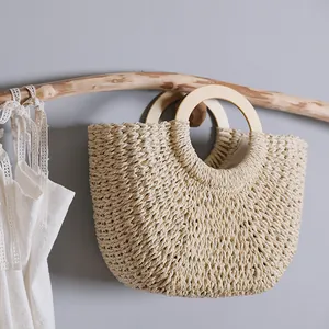 Handcrafted woven straw bag with round wooden handles for summer beach vacations