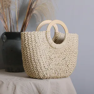 Handmade vintage woven straw bag with circular wooden handles for beach vacation