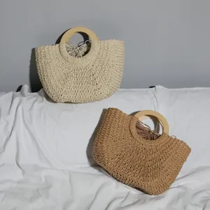 Macro view of retro woven straw beach bags with natural wooden handles