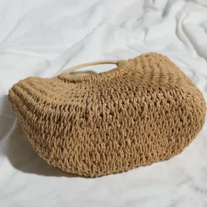 High-quality macro view of retro straw woven bag with circular wooden handles for beach use