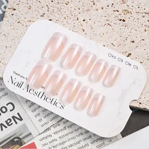 Detailaufnahme von rosa-weißen quadratischen French-Nägeln zum Aufkleben auf Karte