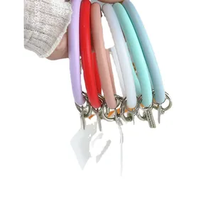 Close-up of colorful silicone O-ring wristlet keychains held by hand in various colors