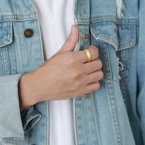 Close-up of a gold matte tungsten steel ring for men worn on a finger