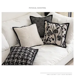 Set of black and white vintage throw pillowcases with floral and houndstooth patterns.