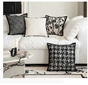 Chic black and cream pattern decorative pillow covers on a white sofa in a cozy room